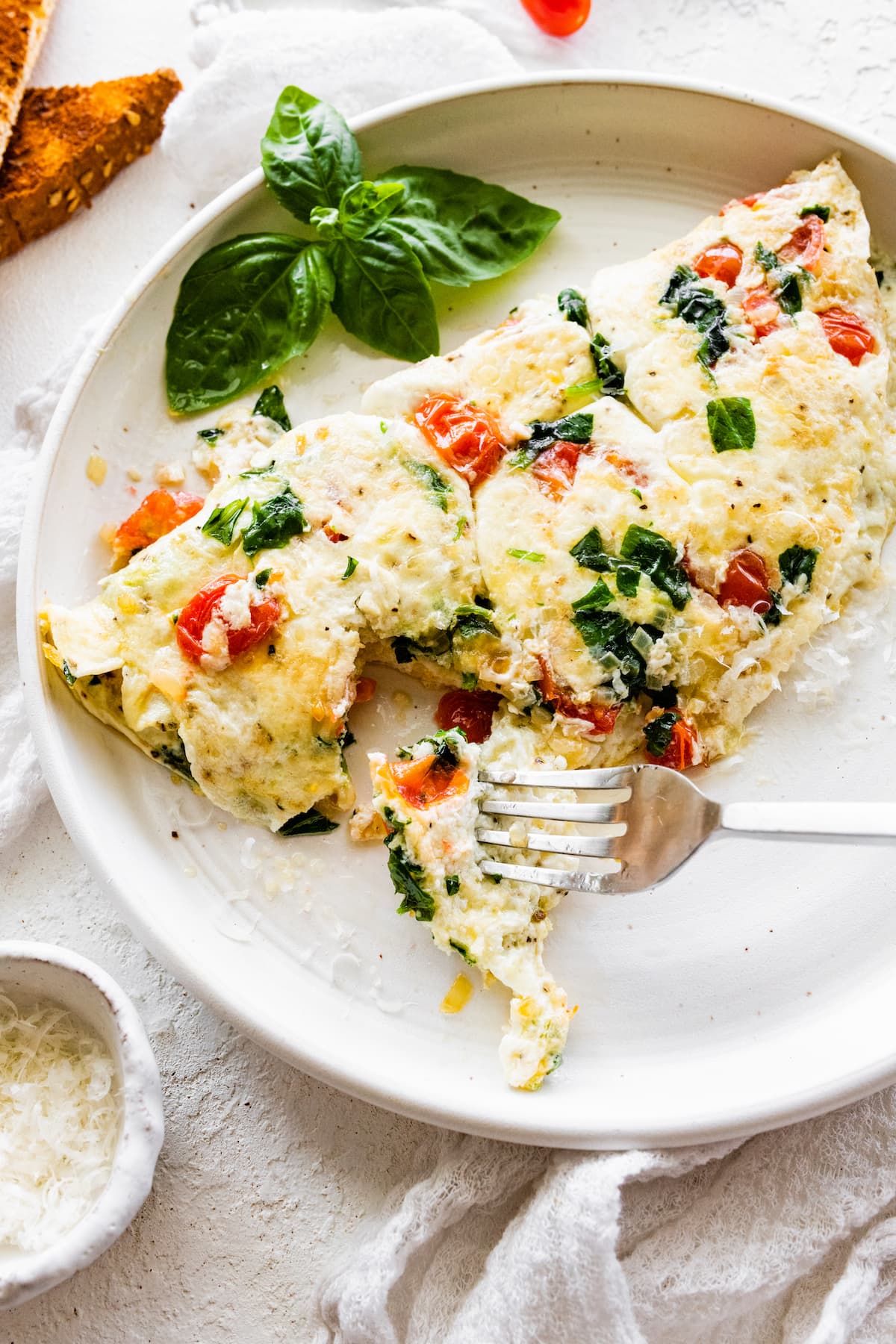 A bite of the egg white omelette being taken with a fork.