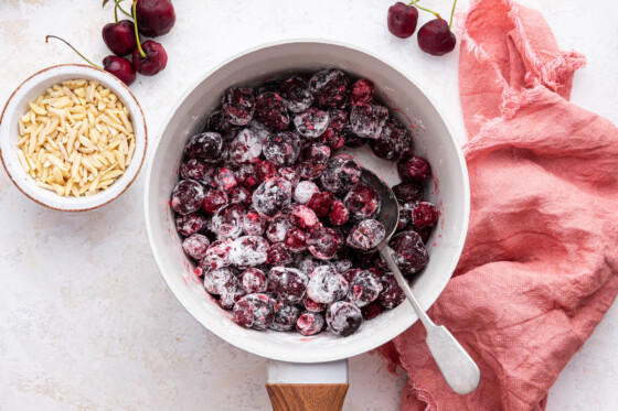 Large cherries covered in arrowroot powder in a saucepan.