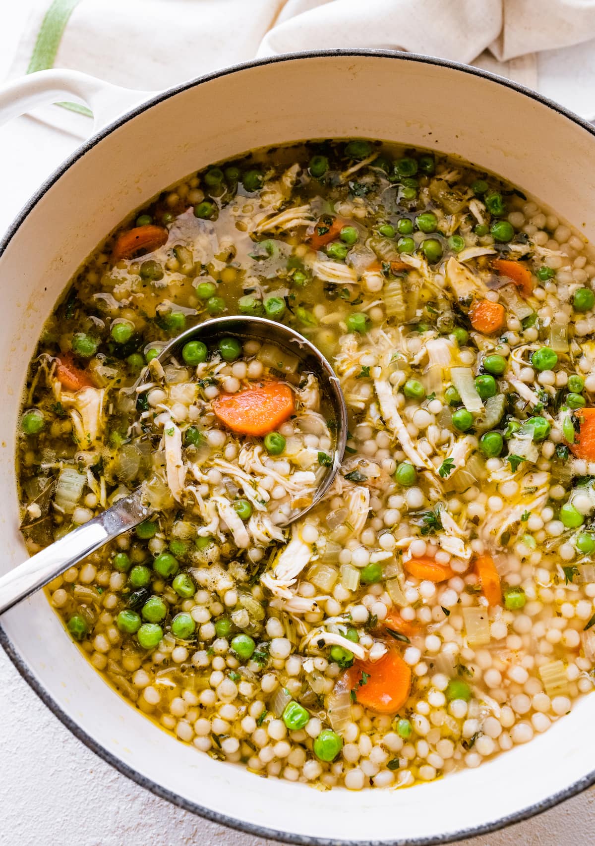 Turkey soup in a large pot with a ladle inside.