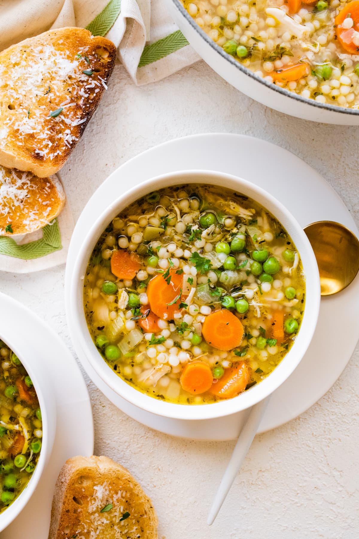 Turkey soup in a white bowl on a plate.