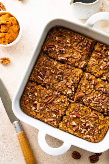 Pumpkin baked oatmeal in a square baking dish cut into 6 pieces.