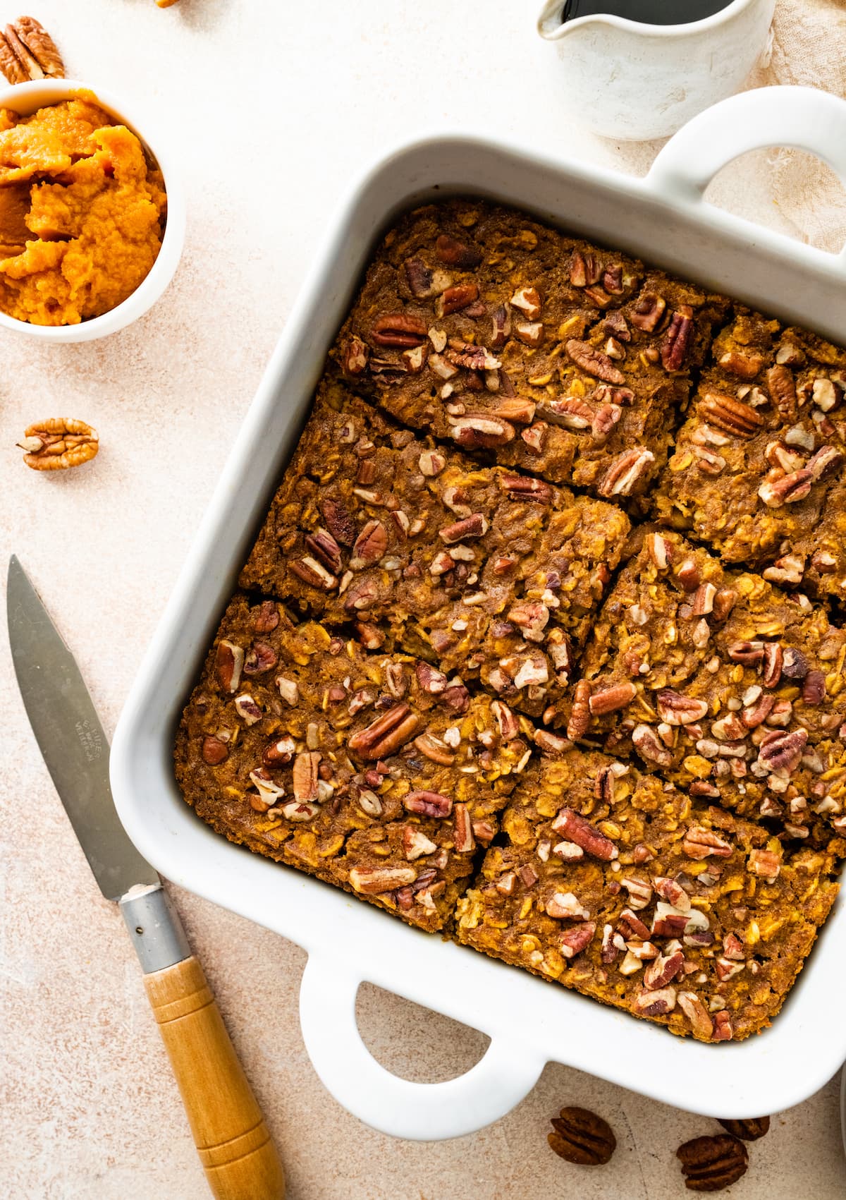 Pumpkin baked oatmeal in a square baking dish cut into 6 pieces.