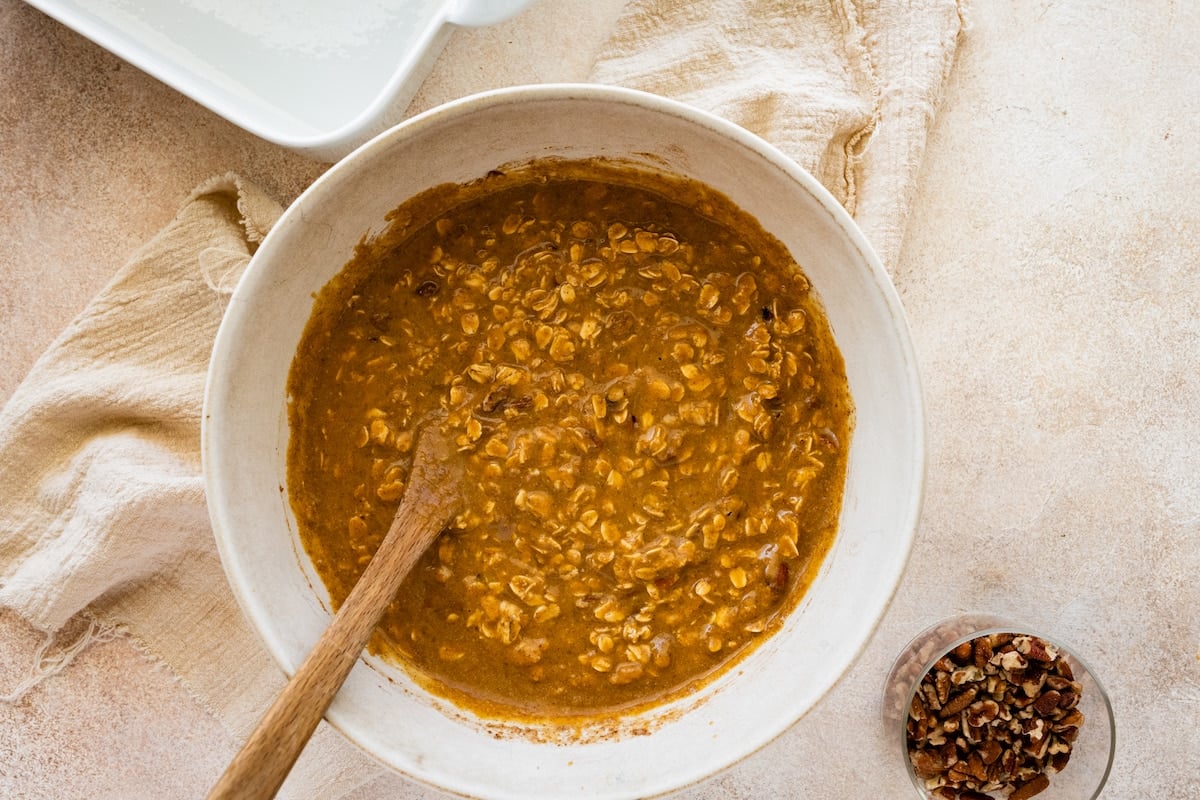 Wet and dry ingredients for the pumpkin baked oatmeal combined in a large mixing bowl.