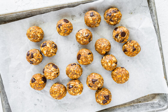 Many pumpkin protein balls on a baking sheet after being baked.