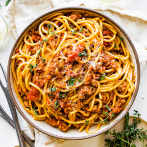 Spaghetti in a shallow bowl mixed together with turkey bolognese.