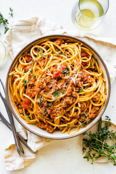 Spaghetti in a shallow bowl mixed together with turkey bolognese.