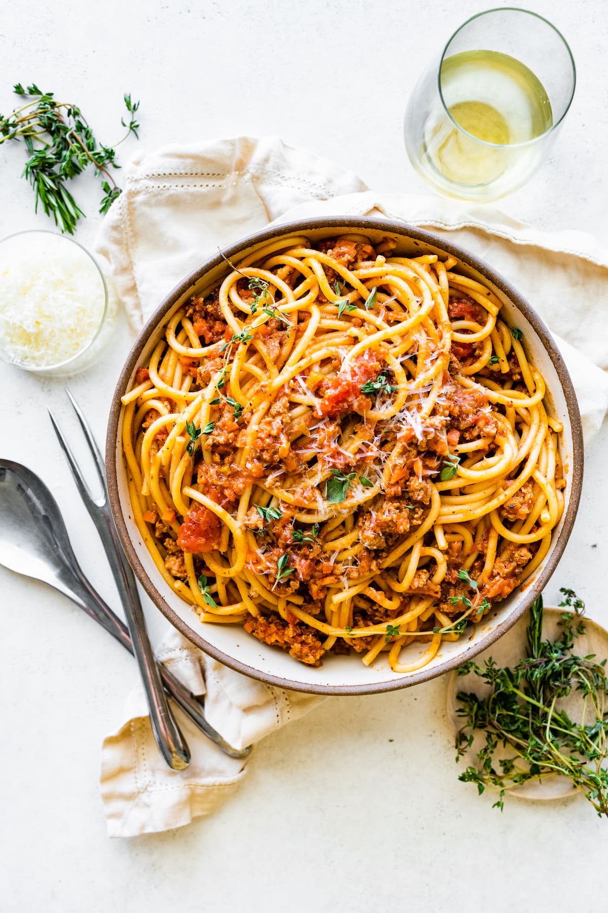 Spaghetti in a shallow bowl mixed together with turkey bolognese.