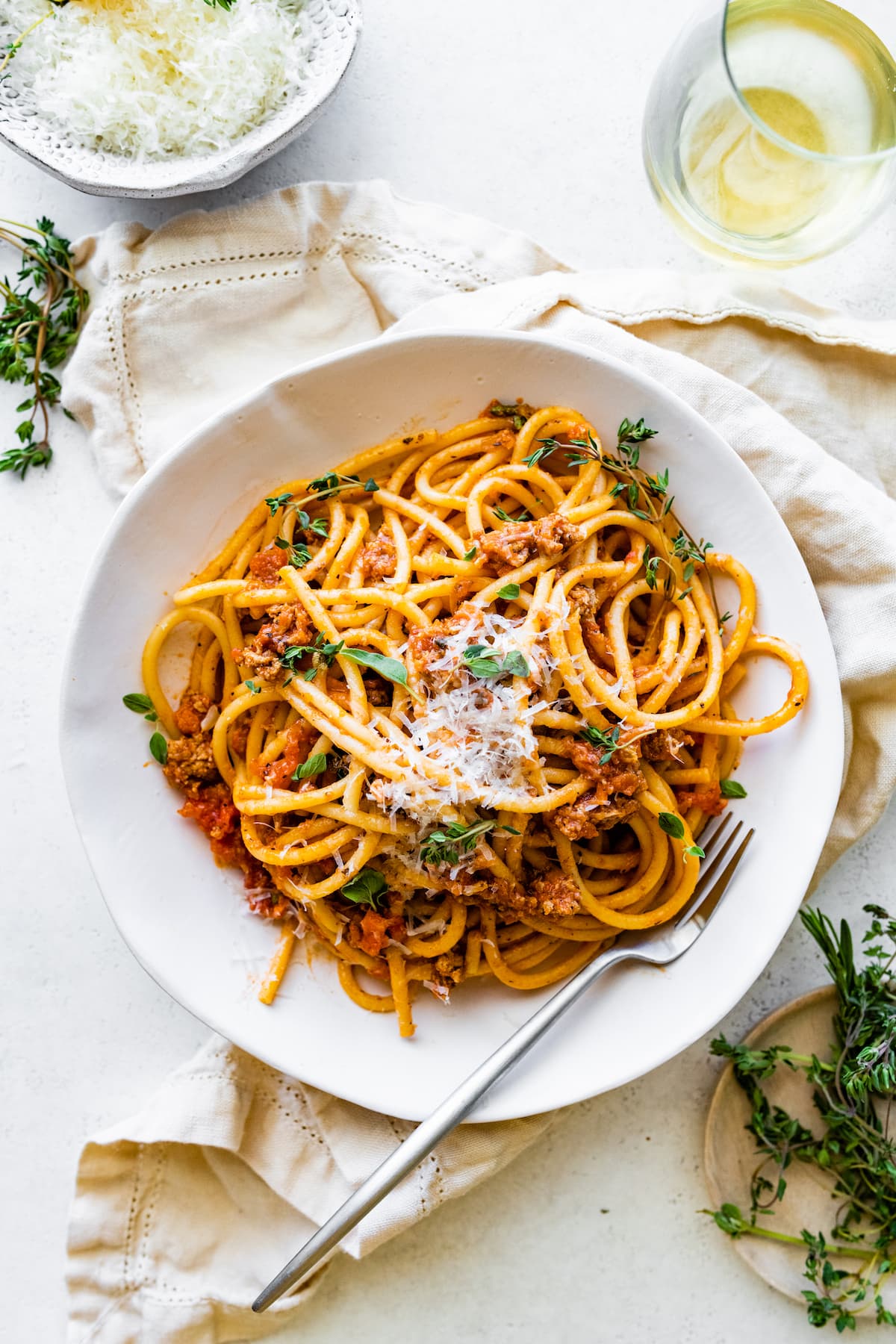 Spaghetti in a shallow bowl mixed together with turkey bolognese.