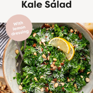 Kale salad in a bowl topped with parmesan and almonds.