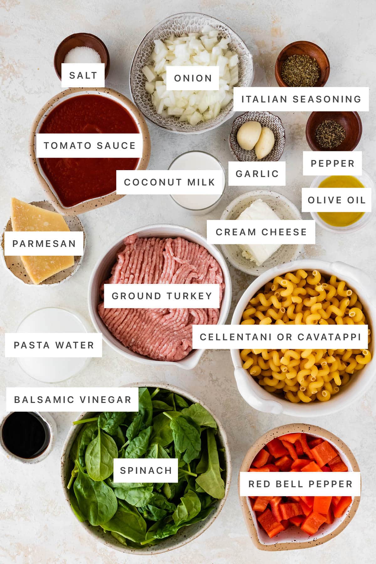 Ingredients measured out to make Ground Turkey Pasta: salt, onion, Italian seasoning, tomato sauce, coconut milk, garlic, pepper, parmesan, cream cheese, ground turkey, olive oil, pasta water, pasta, balsamic vinegar, spinach and bell pepper.