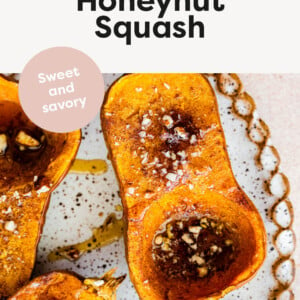 Roasted Honeynut Squash on a platter topped with chopped pecans and maple syrup.