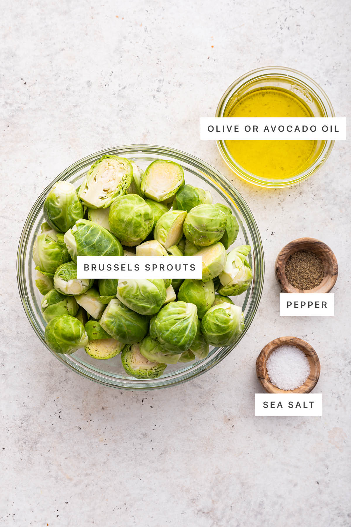 Ingredients measured out to make Roasted Brussels Sprouts: brussels sprouts, olive or avocado oil, pepper and sea salt.