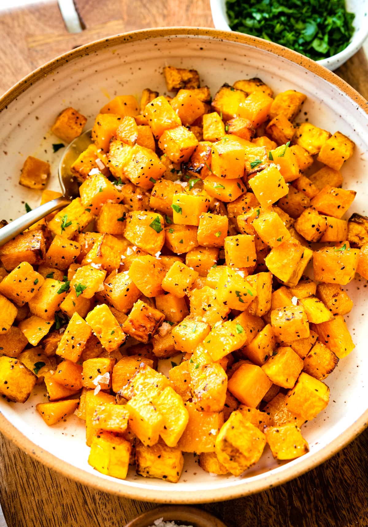 Cubed and seasoned air fried butternut squash on a large plate.