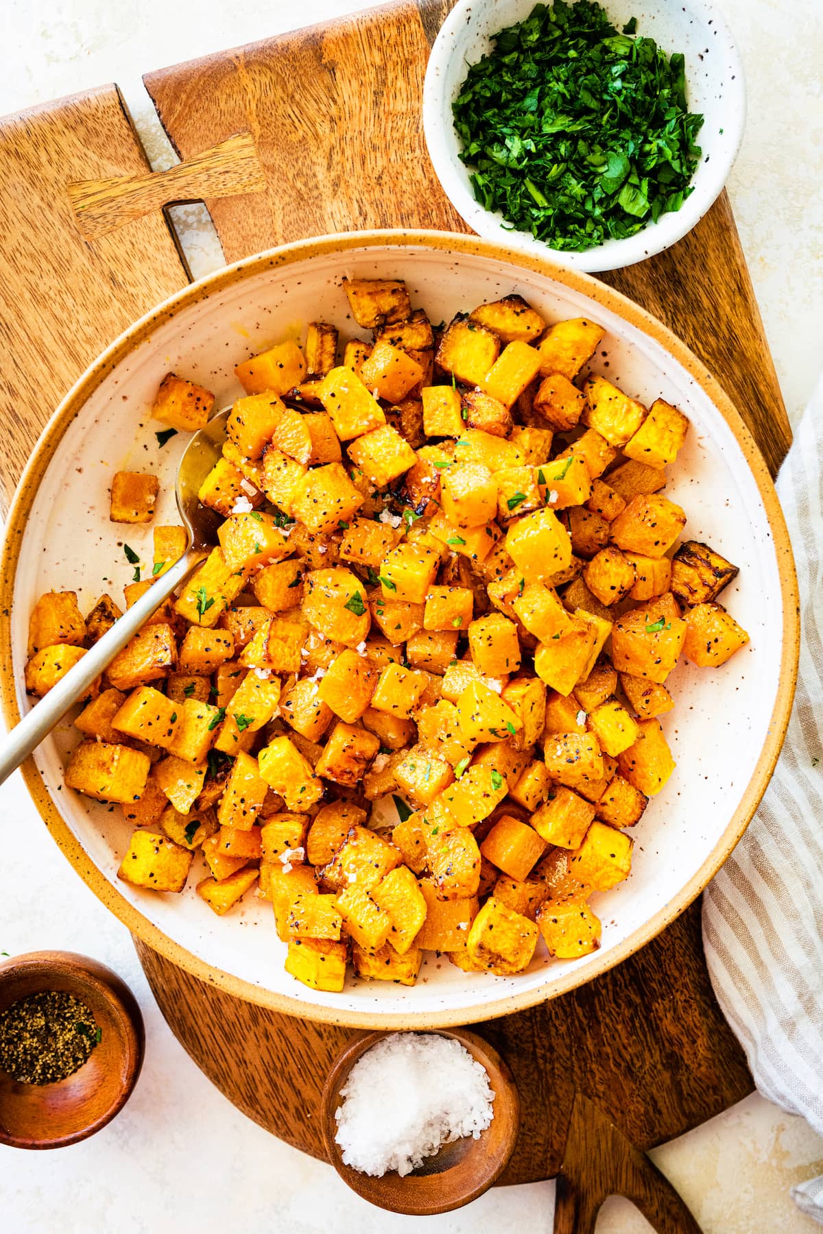 Seasoned and cubed butternut squash on a plate.