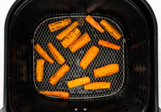 Carrots in an air fryer after being air fried.