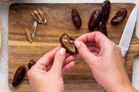 A woman's hand de-pitting a date.