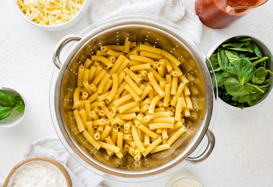 Cooked pasta noodles in a metal colander.