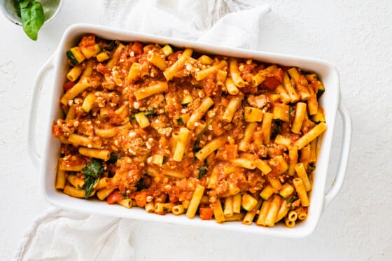 Pasta noodles and ground turkey tomato sauce mixed together in a large square baking dish.
