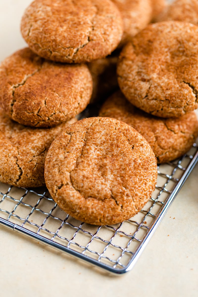 Multiple gluten-free snickerdoodle cookies on a wire rack.