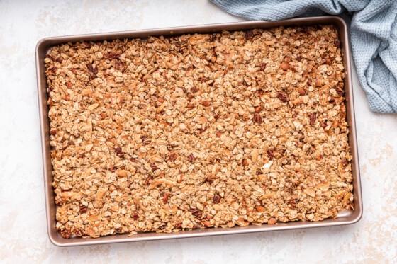Homemade granola on a baking sheet after being toasted in the oven.