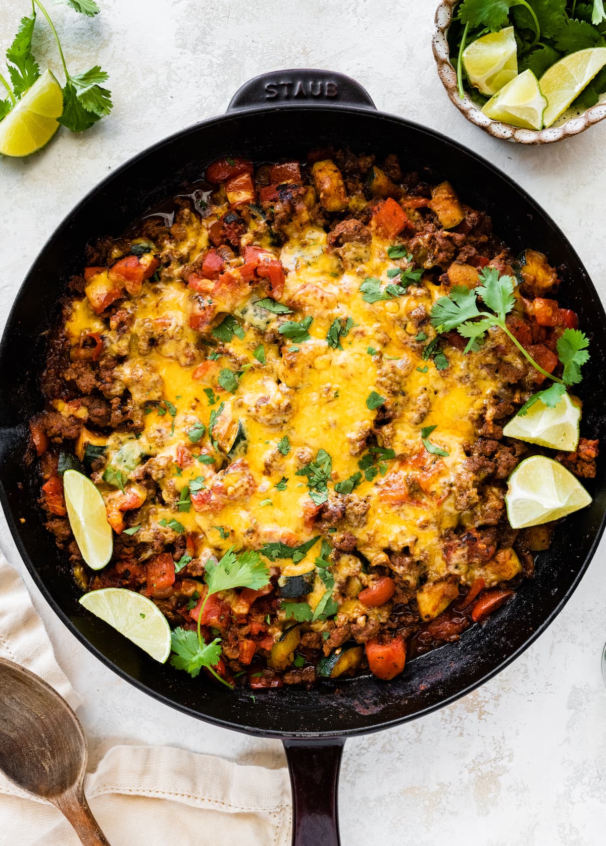 Ground beef and squash in a large skillet topped with melted cheddar cheese.