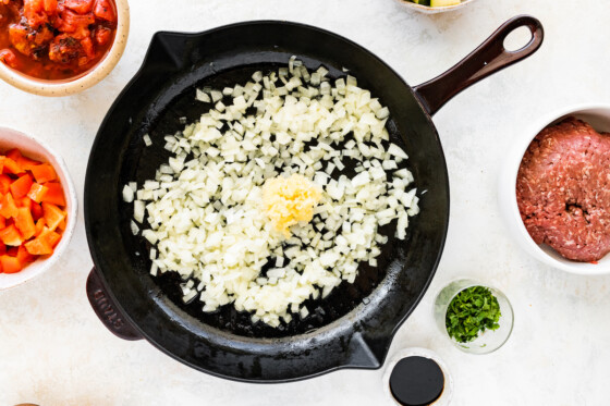 Diced onion and garlic in a large cast iron skillet.