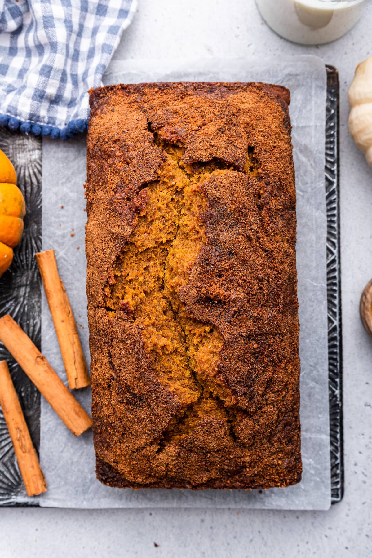 A loaf of healthy pumpkin bread on parchment paper on a cutting board.