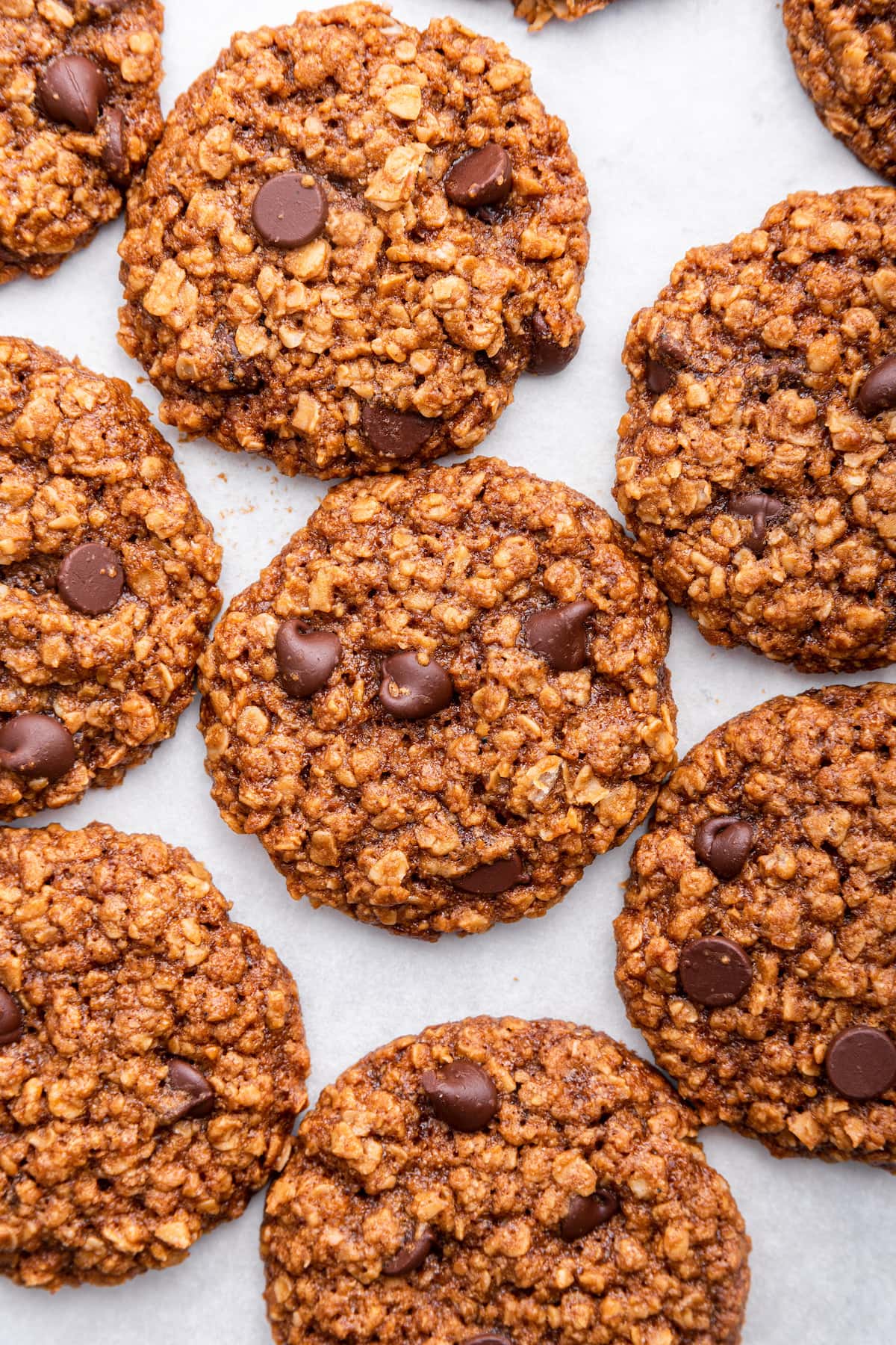 Multiple chocolate chip lactation cookies near one another on parchment paper.