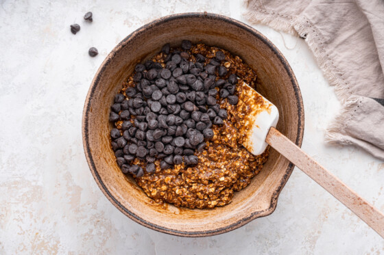 Chocolate chips added to a large mixing bowl containing the dough for the lactation cookies.