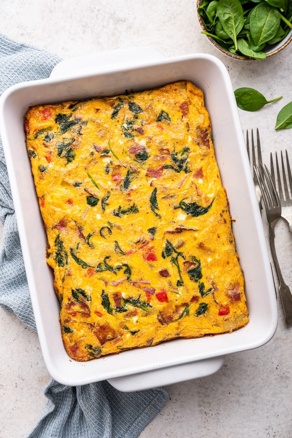 An egg casserole in a square baking dish.