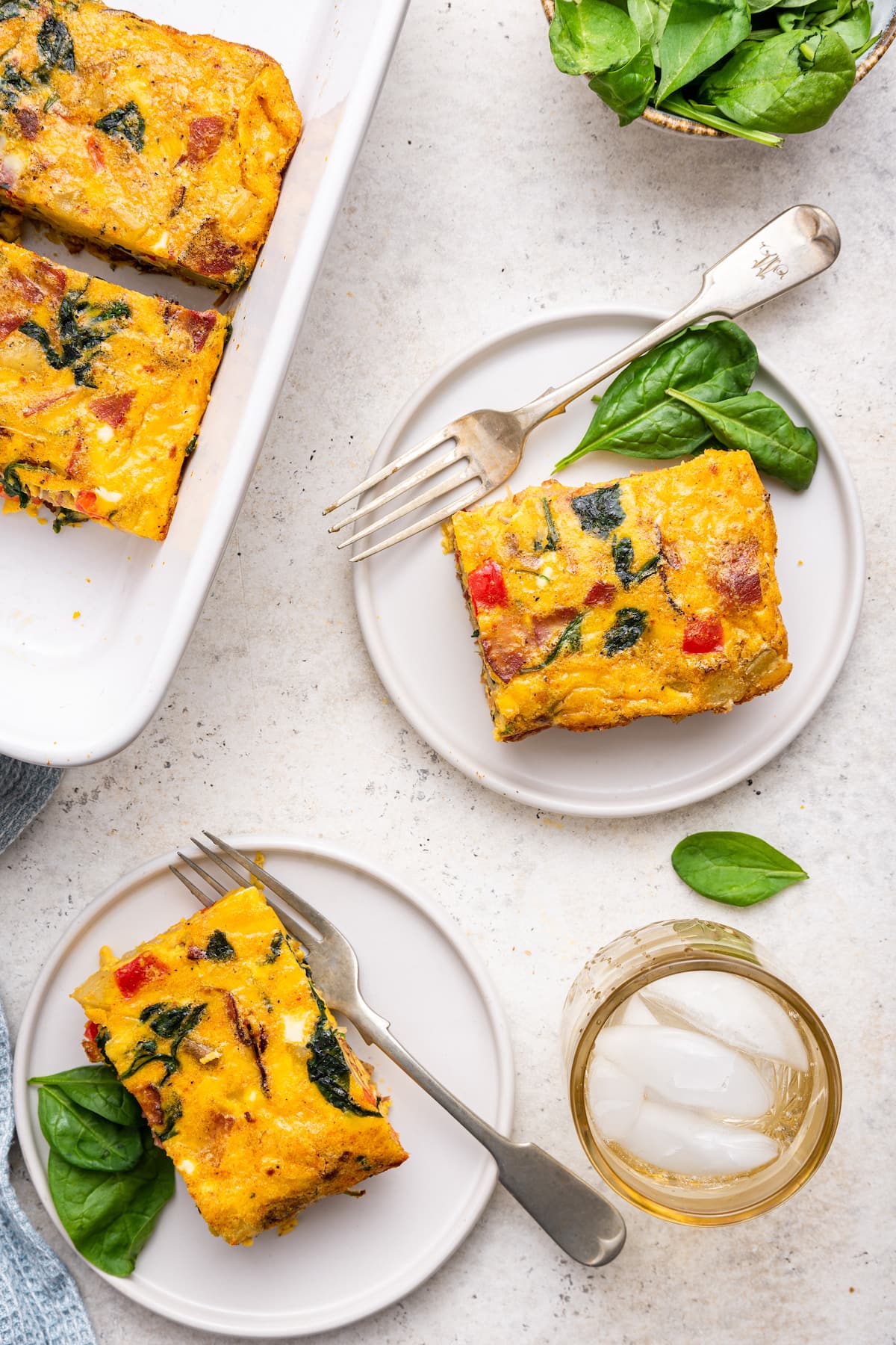 Two small white plates each with a serving of an egg casserole.