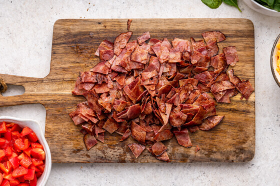 Chopped turkey bacon on a wooden cutting board.