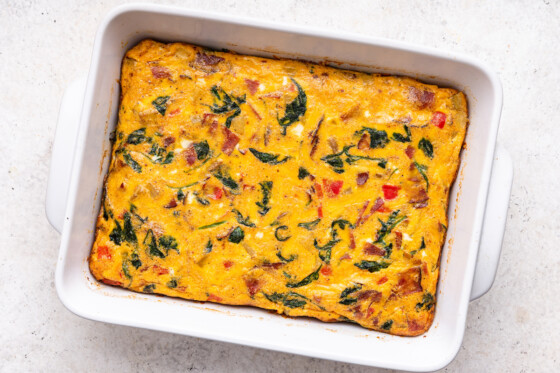 A complete egg casserole in a large square baking dish after being baked in the oven.