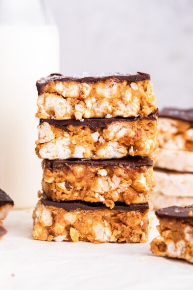 Four no bake peanut butter crunch bars stacked on one another.