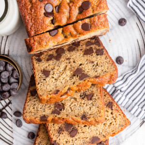 Protein banana bread with chocolate chips cut into multiple slices that are leaning on one another.