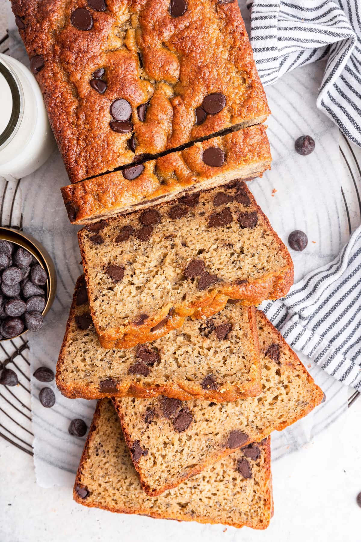 Protein banana bread with chocolate chips cut into multiple slices that are leaning on one another.