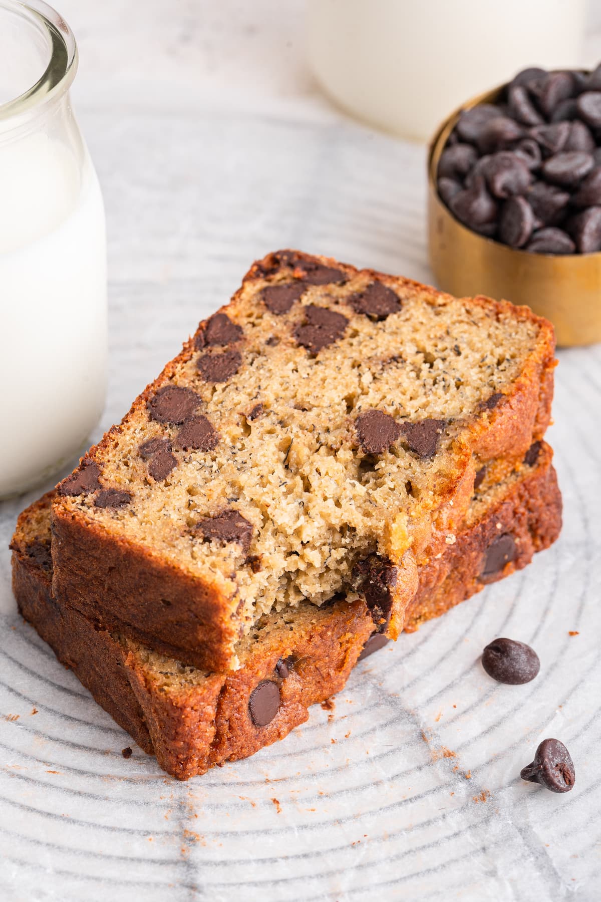 Two slices of protein banana bread stacked on one another with a small bite taken from one that is on top.