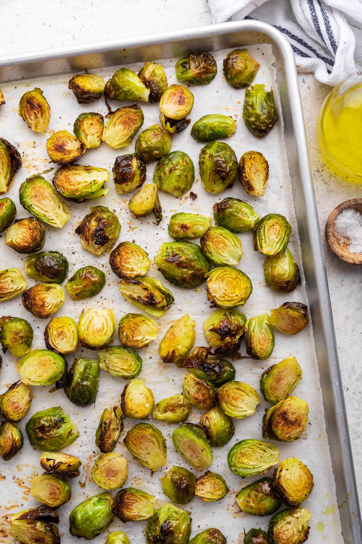 Roasted brussels sprouts on parchment paper on a baking tray.