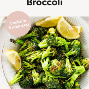 Bowl of Air Fryer Broccoli served with red pepper flakes and lemon slices.