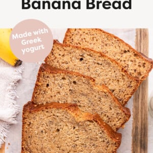 Slices of Healthy Banana Bread from a loaf on a wood cutting board lined with parchment paper.