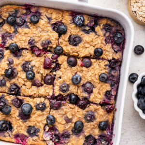 Blueberry baked oatmeal cut into six bars in a square baking dish.
