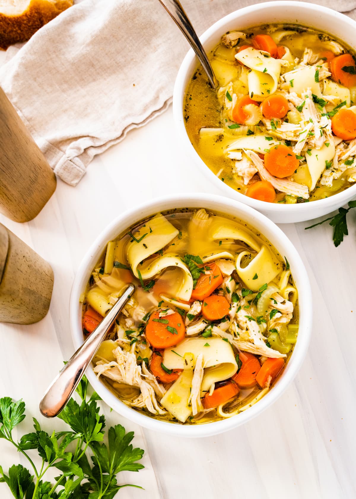 Two bowls of chicken noodle soup.