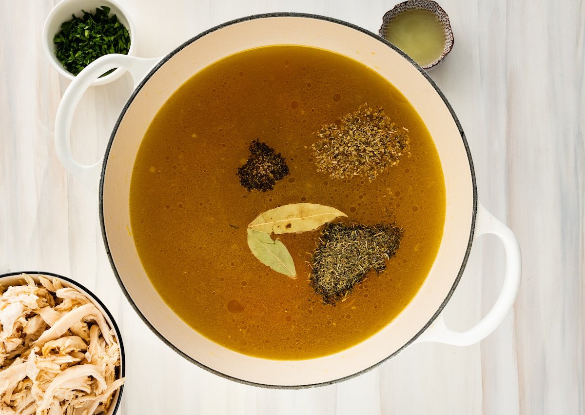 Chicken broth with herbs and spices in a large pot.