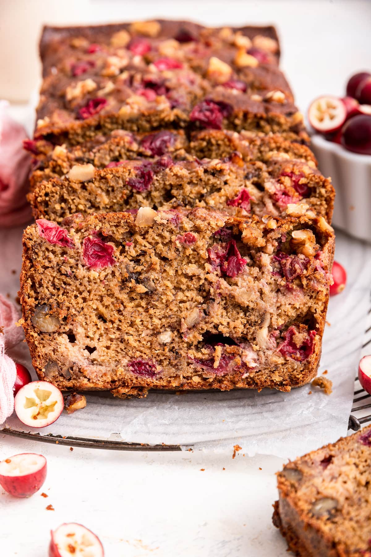 Sliced cranberry banana bread on parchment paper.