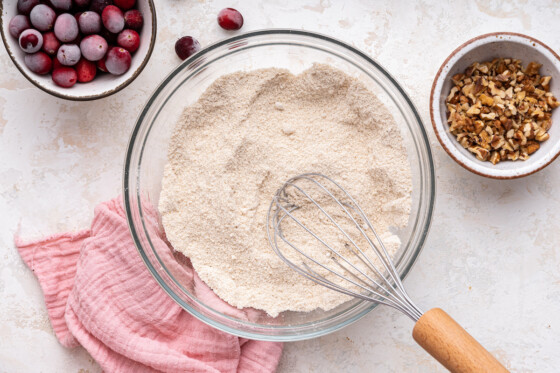 Flour with a metal whisk in a glass bowl.