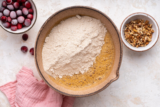 Wet and dry ingredients for the cranberry banana bread combined in a large mixing bowl.