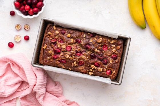 A loaf of cranberry banana bread in a loaf pan.