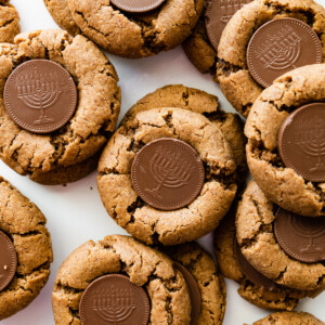 Multiple peanut butter blossoms with a chocolate coin that depicts a menorah in the center of each cookie.