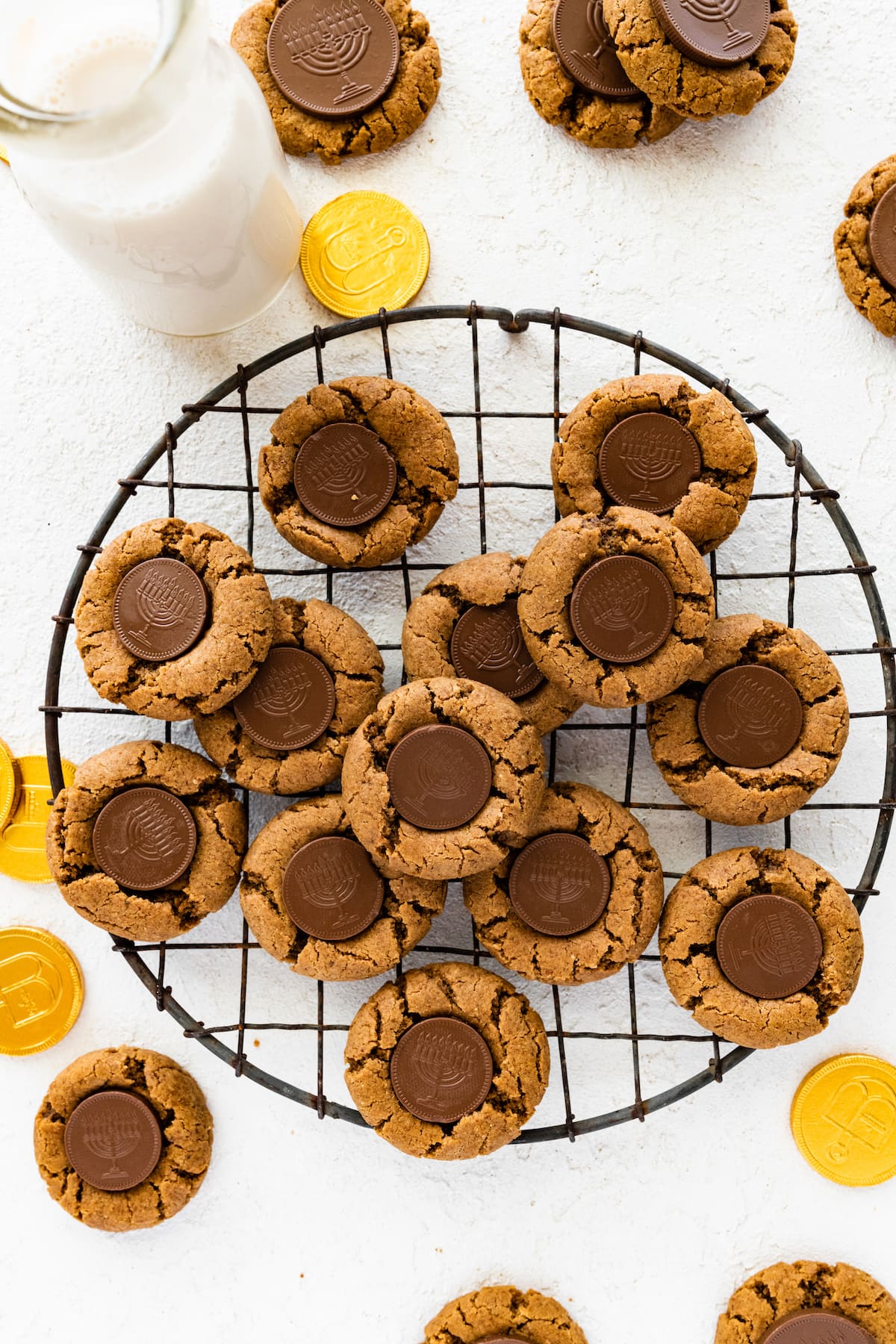 Multiple peanut butter blossoms with a chocolate coin that depicts a menorah in the center of each cookie.