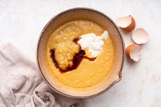 Banana, yogurt, and vanilla added to the beat eggs in a large mixing bowl.